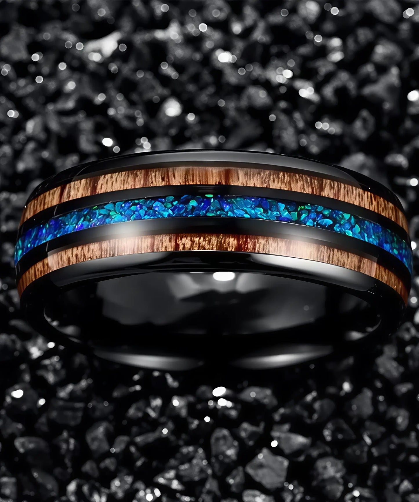 Bague en bois Ark Benetto en tungstène noir avec incrustation d’opale bleue et liserés en bois naturel, posée sur fond de pierres noires