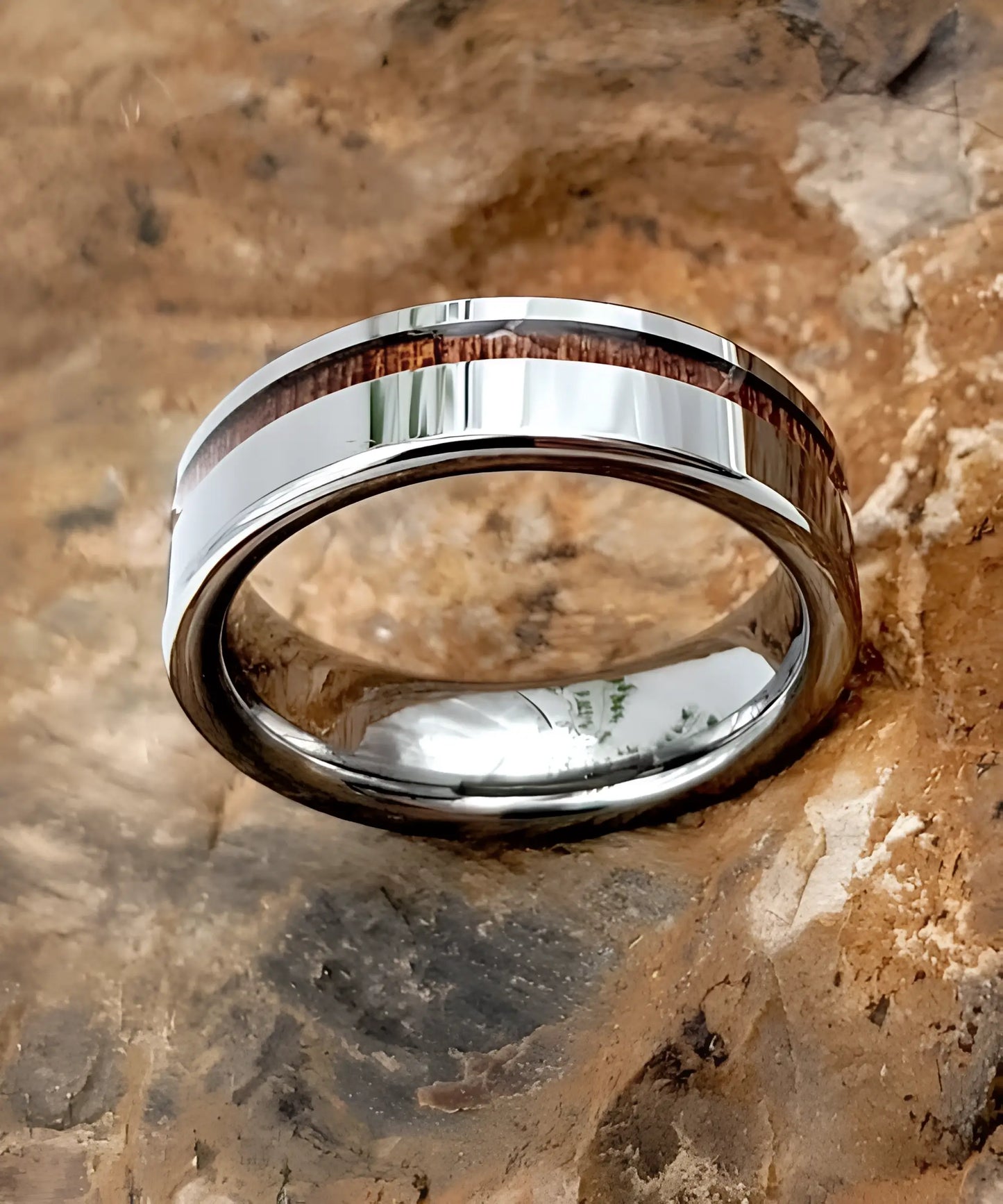 Bague en bois Ultron Sim argent posée sur une roche naturelle, alliant élégance du tungstène et authenticité du bois