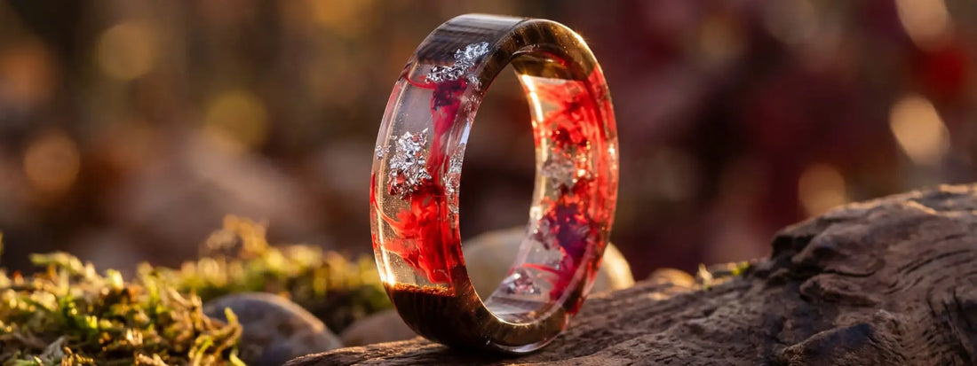 bague bois et résine rouge transparente avec inclusions brillantes bijou artisanal effet lumière sur fond nature