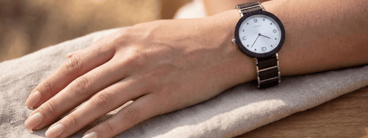 montre en bois femme portée au poignet style minimaliste élégant cadran clair bracelet métal et bois ambiance naturelle