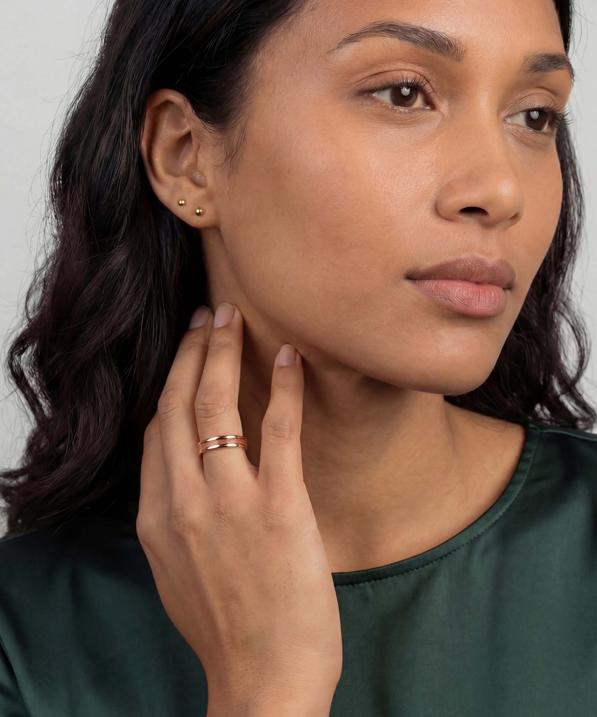 Bague fortune tana bois naturel et or rose portée au doigt, alliance fine et élégante au style minimaliste, finition or rose raffinée.