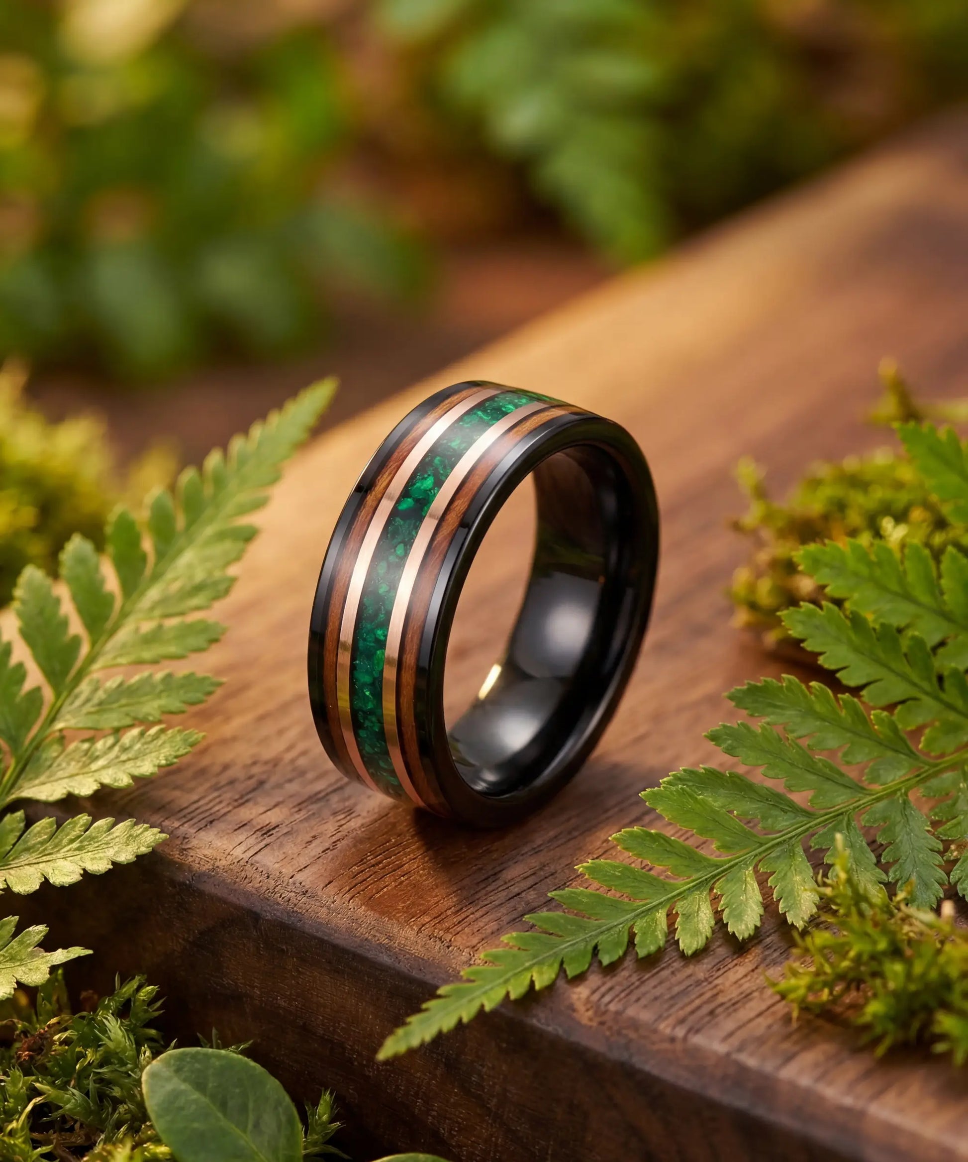 Bague en bois Ark Nomad opale posee sur bois tropical avec fougeres vertes, alliance bois tungstene opale