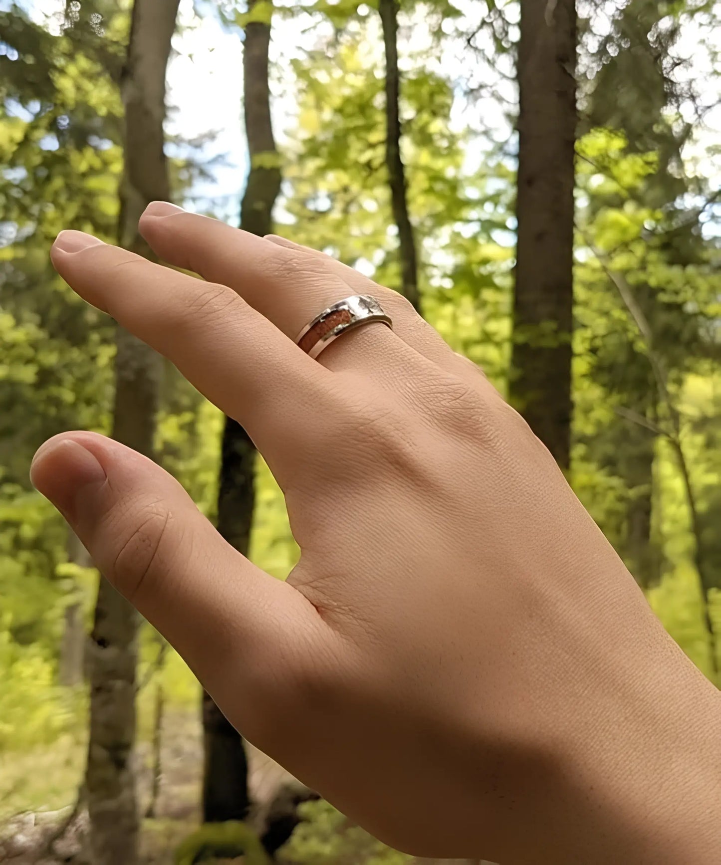 Main masculine portant une bague en bois et acier inoxydable gravée Arbre de Vie, alliance naturelle et élégante.