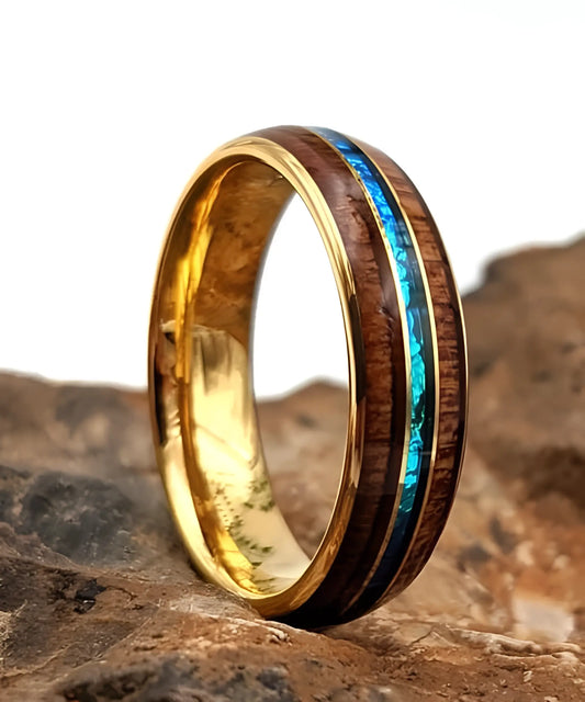 Bague en bois Ark en or jaune avec incrustation turquoise posée sur une pierre en décor naturel
