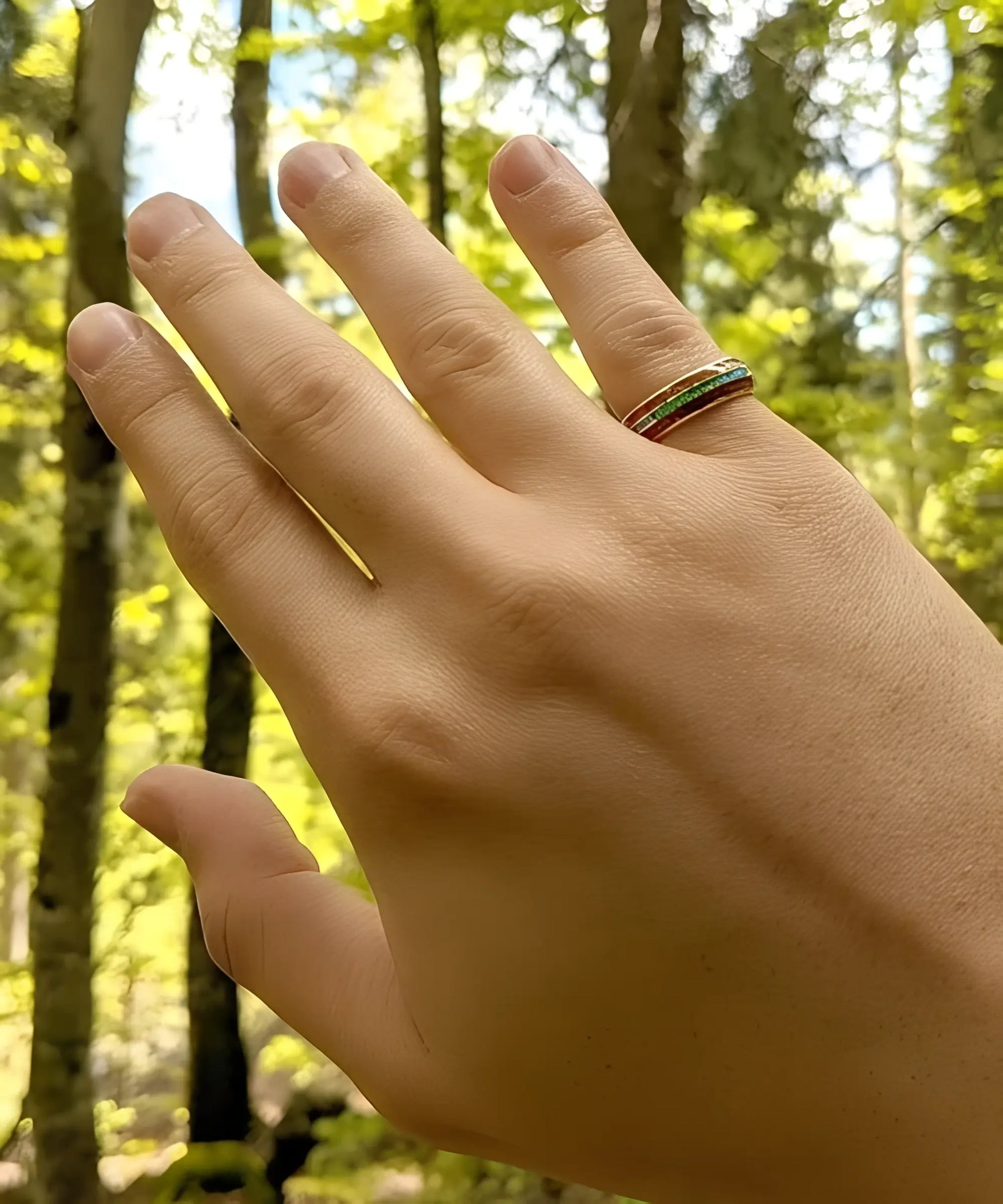 Bague en bois Ark en or jaune avec incrustation turquoise portée à la main en pleine nature