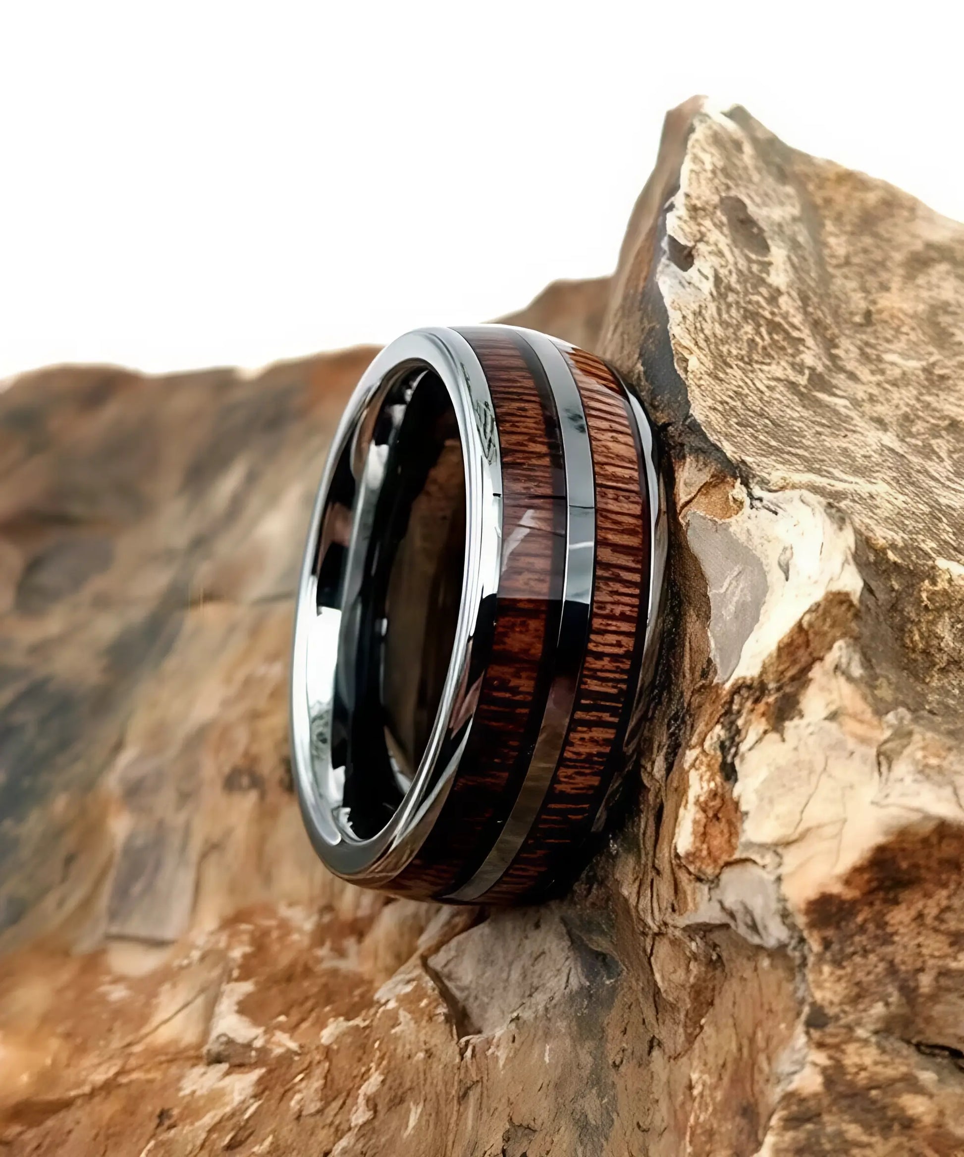 Bague en bois Duo Primordial Ève posée sur une roche, anneau en tungstène argenté avec double incrustation de bois exotique
