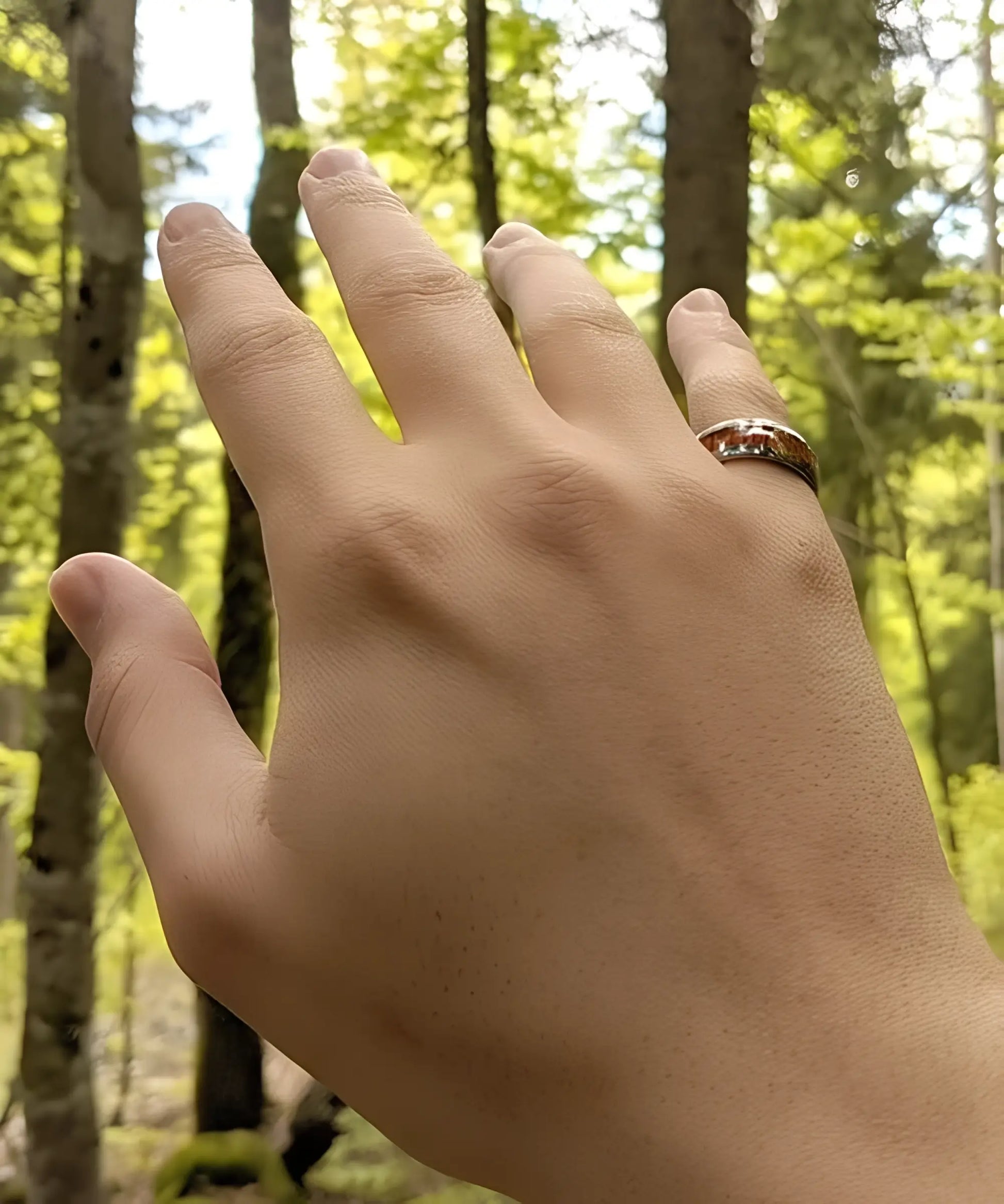 Bague en bois Elior Dim argent porté à la main d'un homme, anneau en tungstène argenté avec incrustation de bois de koa