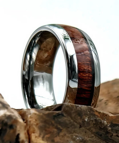 Bague en bois Elior Dim argent posée sur une pierre, alliance en tungstène avec incrustation de bois de koa naturel et finition argentée brillante