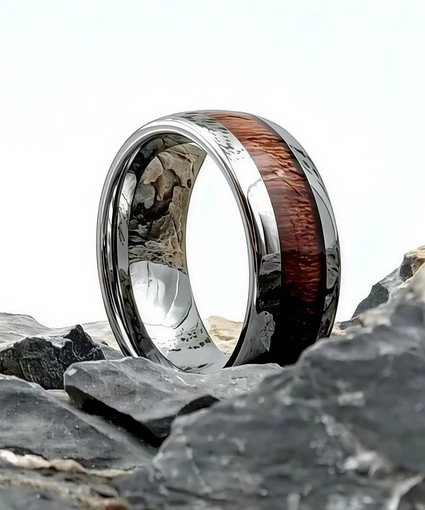 Bague en bois Elior Dim argent posée sur des rochers, anneau en tungstène argenté poli avec incrustation de bois de koa.