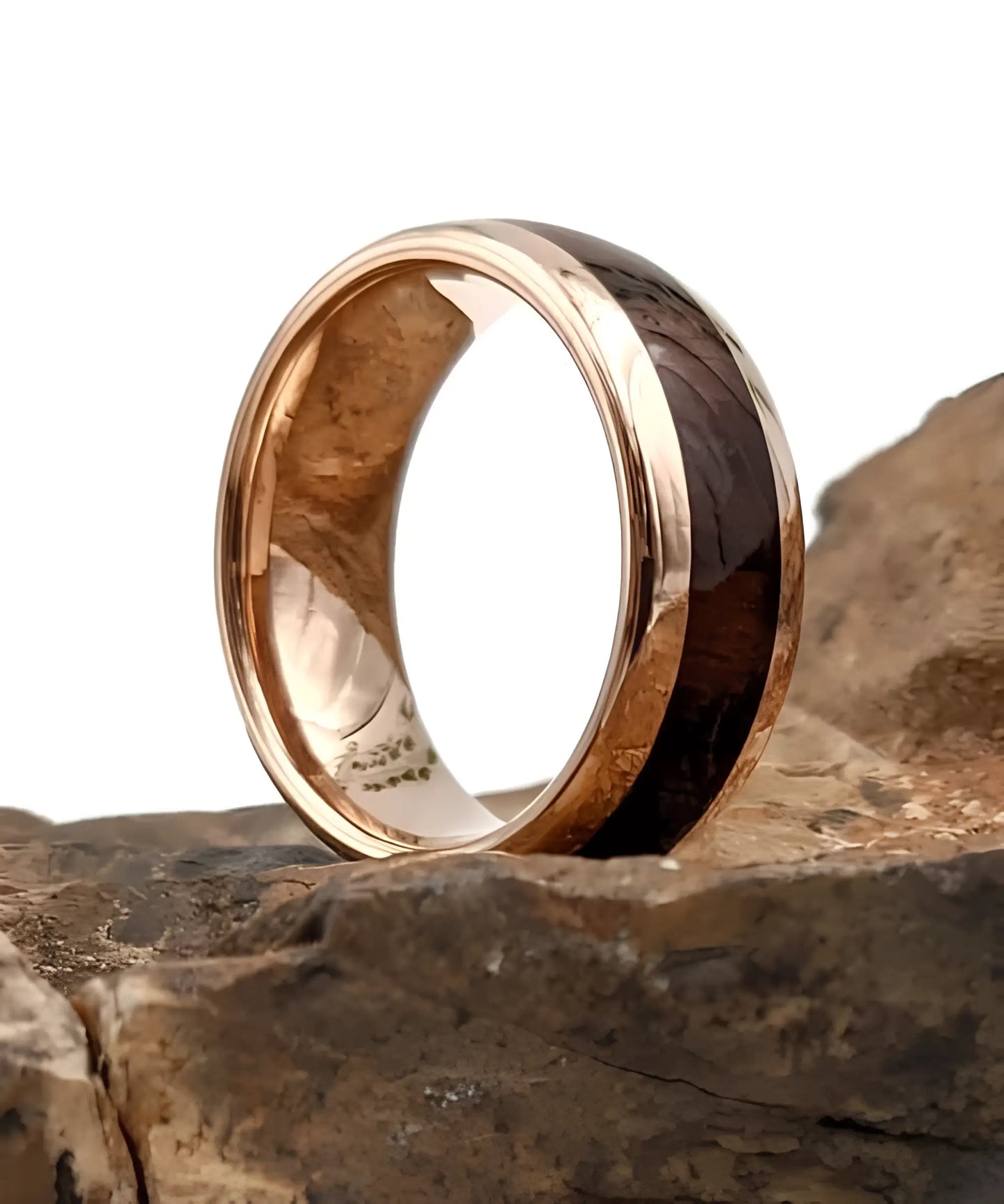 Bague en bois Elior Révo avec incrustation de bois sombre et contours en métal rose doré, posée sur une pierre naturelle