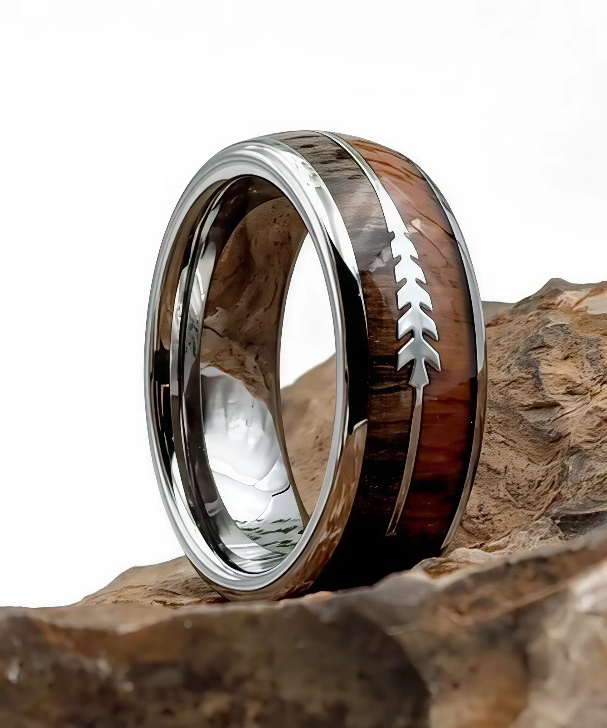 Bague en bois Flèche de Cupidon argent Passion posée sur des roches, anneau en tungstène poli avec incrustation bois naturel et flèche symbolisant l’amour éternel