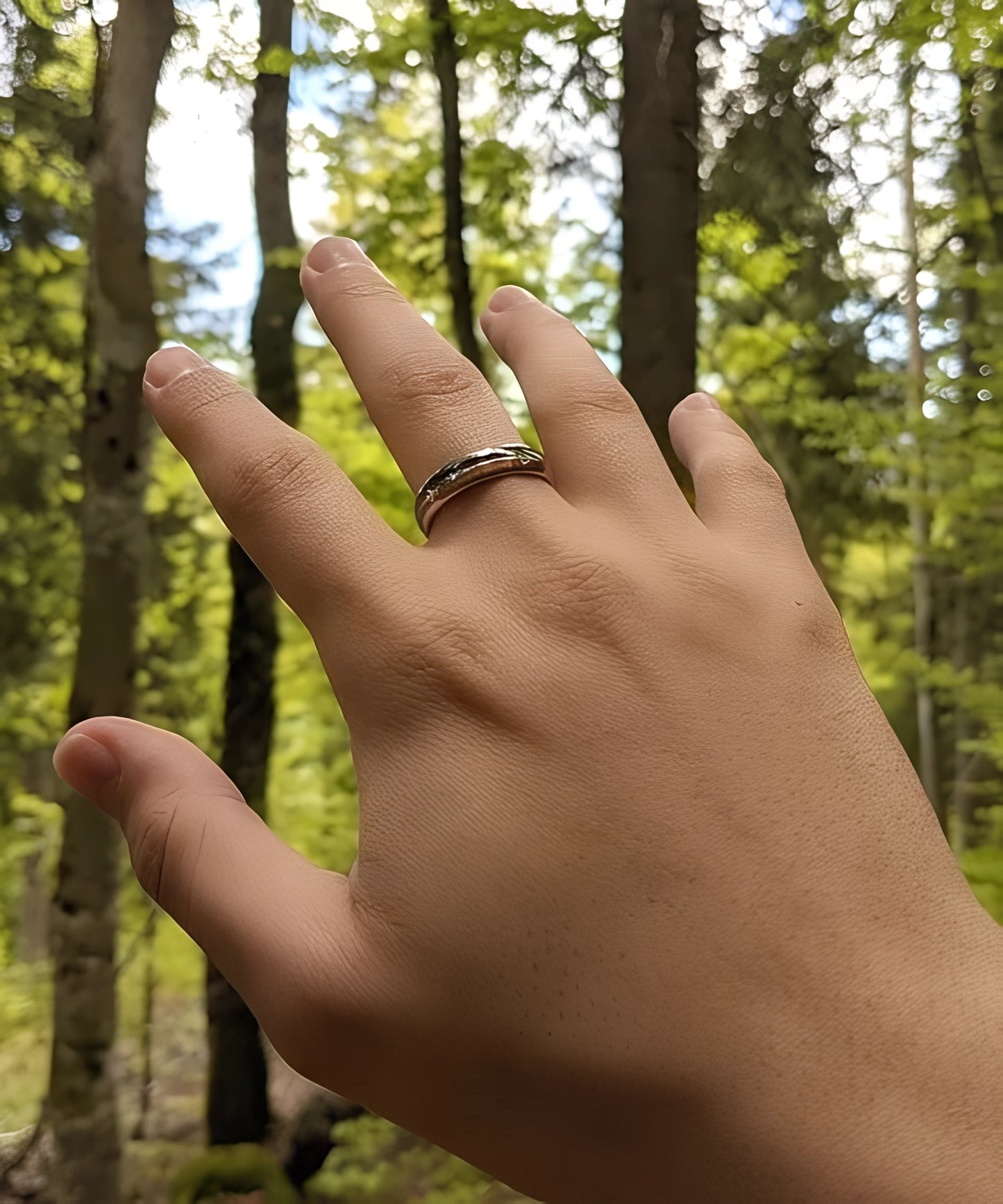 Main portant la bague en bois Flèche de Cupidon Argent Passion Sim, alliance en tungstène et bois avec motif flèche gravé, photographiée en pleine nature.