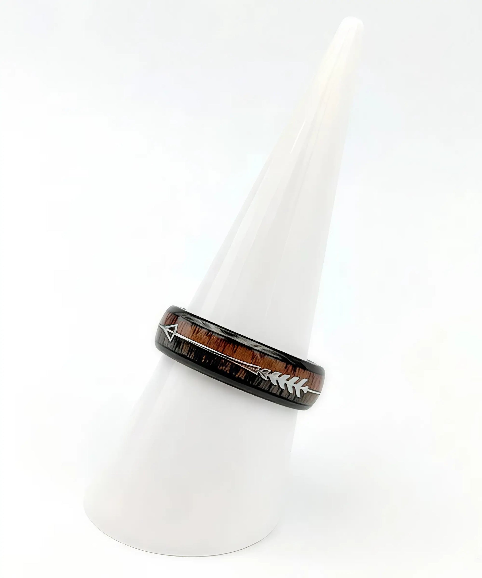 Bague en bois Flèche de Cupidon noire Passion Sim 6 mm en tungstène noir, incrustation de bois de koa clair et sombre, décorée d’une flèche argentée, posée sur un présentoir blanc.