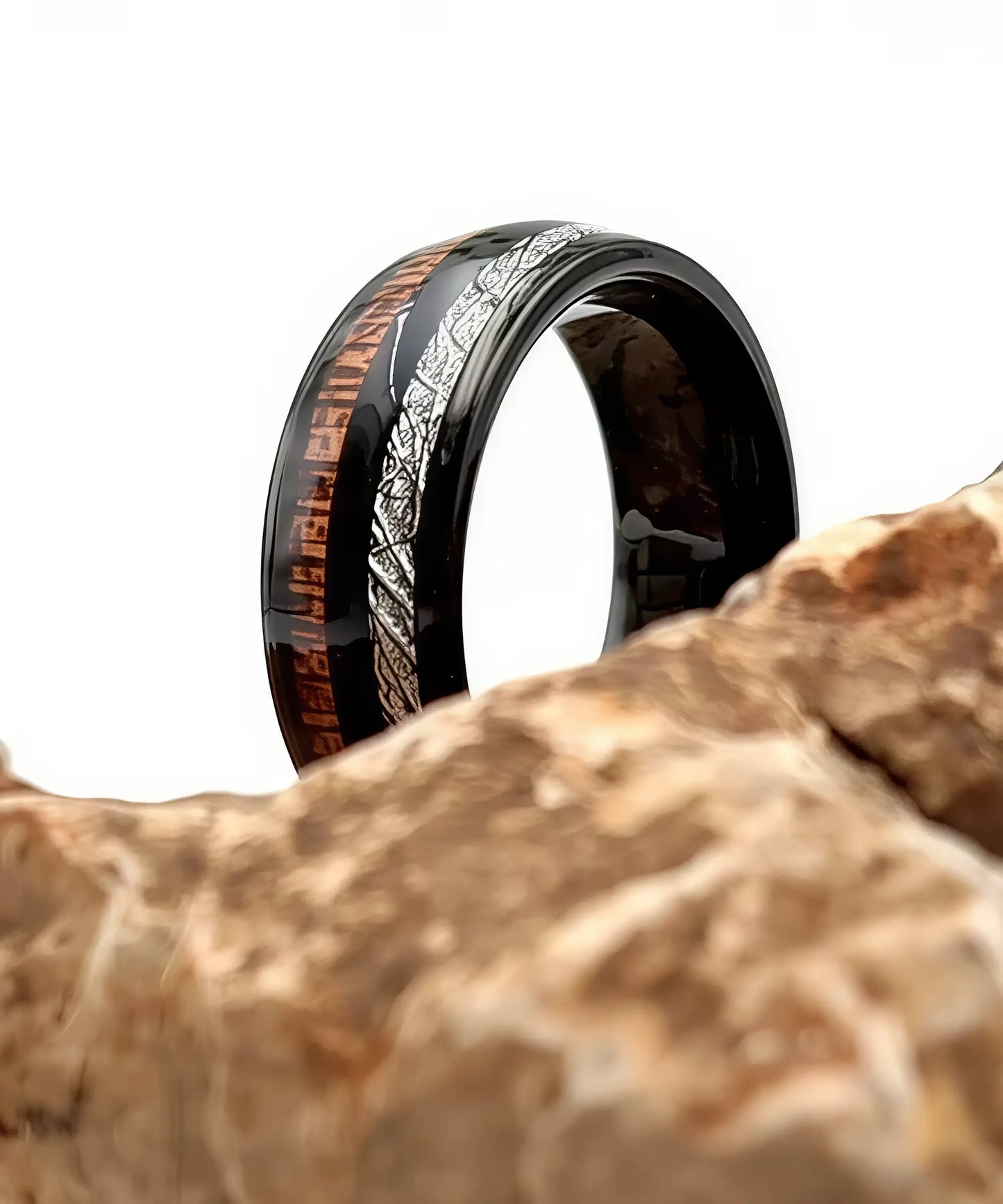 Bague en bois homme Duo d’Eden posée sur une roche, alliance noire élégante avec incrustation bois exotique et motif argenté