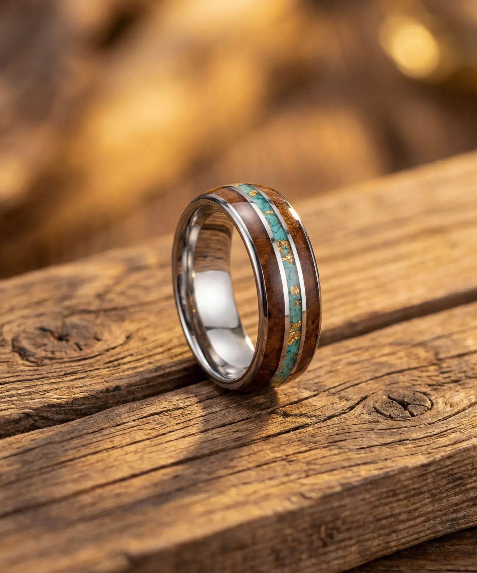 Bague en bois et tungstène avec incrustation bleue posée sur une surface en bois naturel