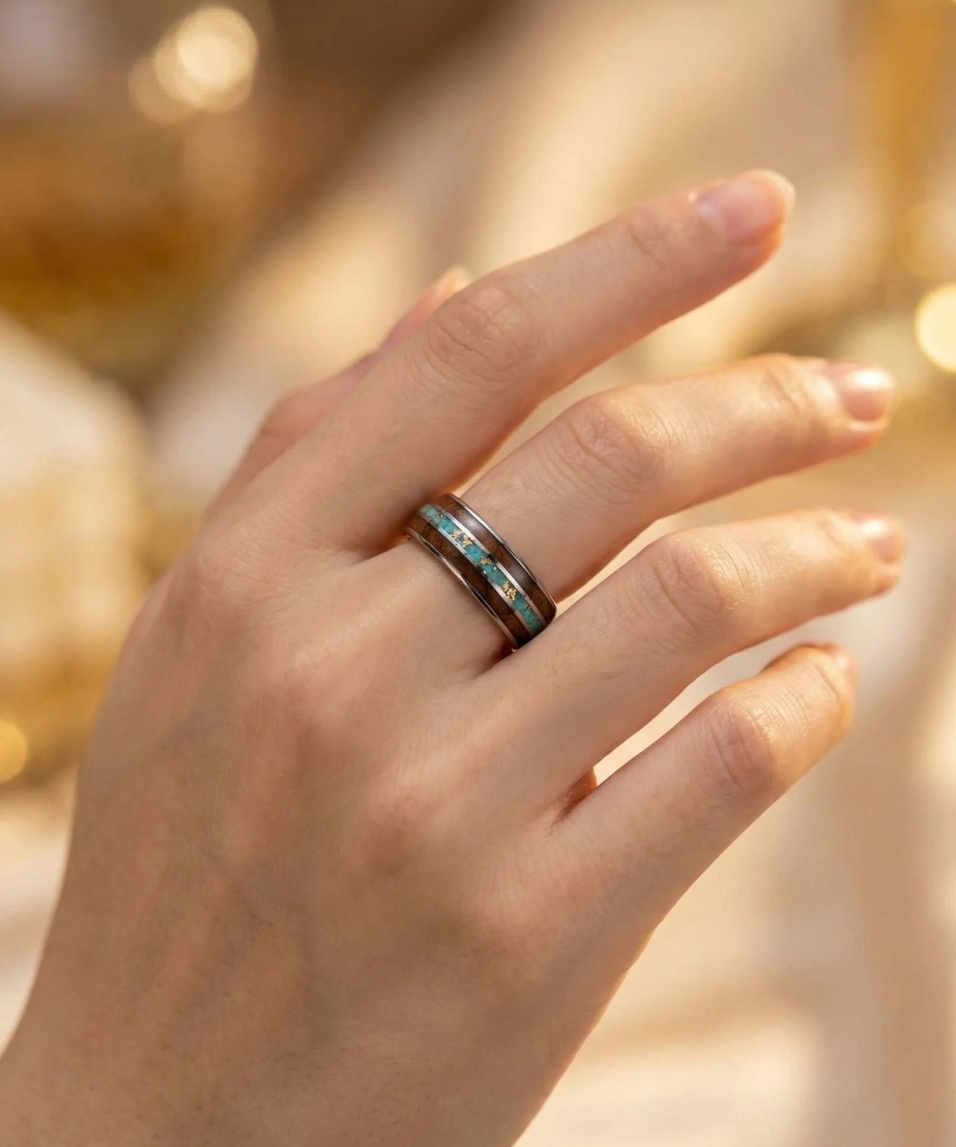 Bague en bois et tungstène avec incrustation bleue portée au doigt sur une main féminine