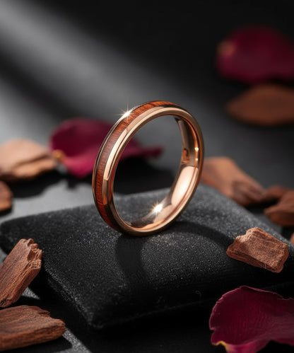 Alliance Elior Rose en bois et métal doré, posée sur un coussin noir avec pétales et éclats de bois sous une lumière douce