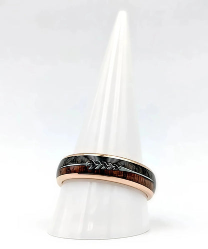 Bague en bois Flèche de Cupidon rose Passion Sim, anneau en tungstène or rose avec incrustation bois et motif flèche, présentée sur un cône blanc minimaliste