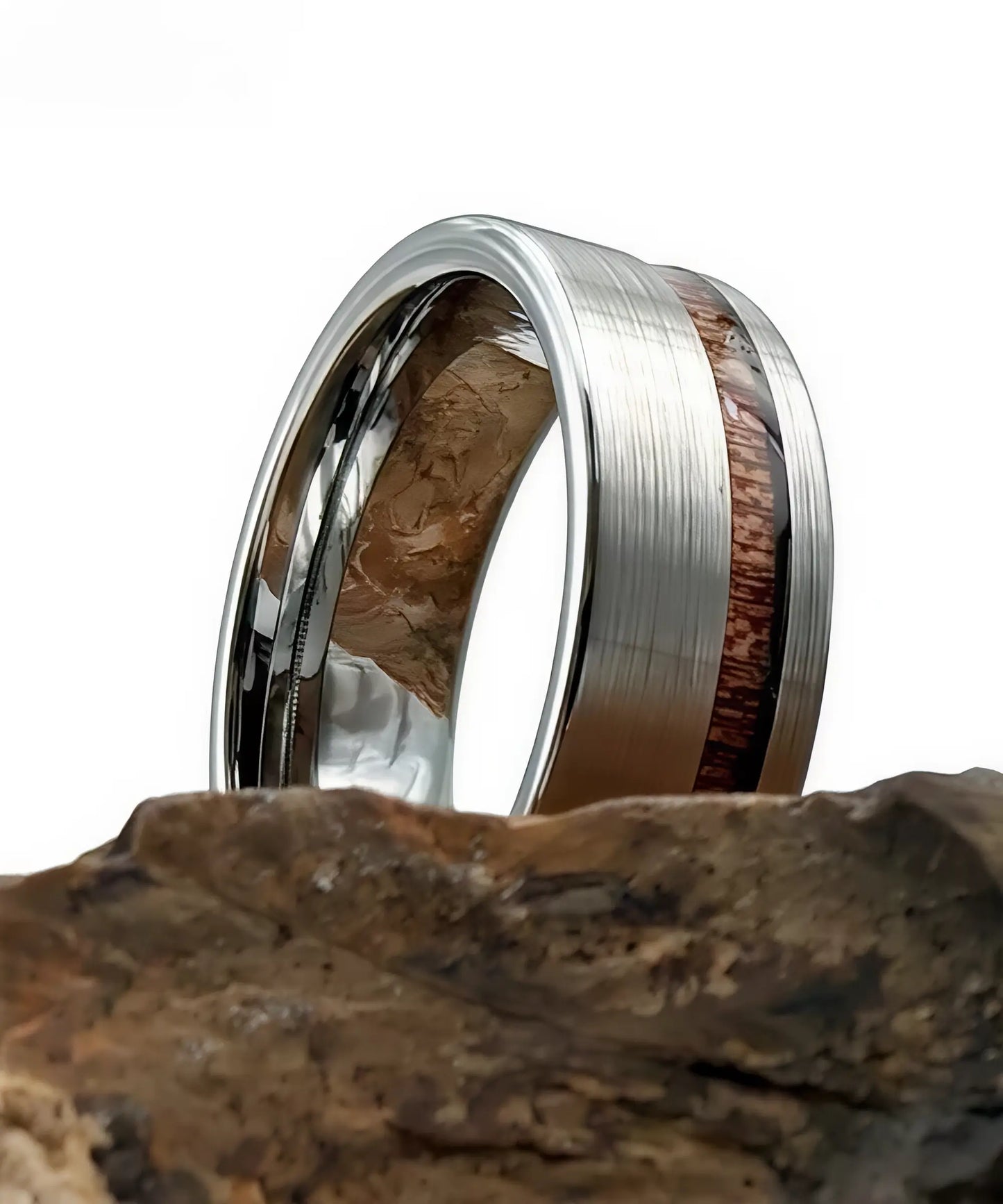 Bague en bois Ultron Ram argent en tungstène finition brossée avec incrustation de bois de koa, présentée sur une roche naturelle