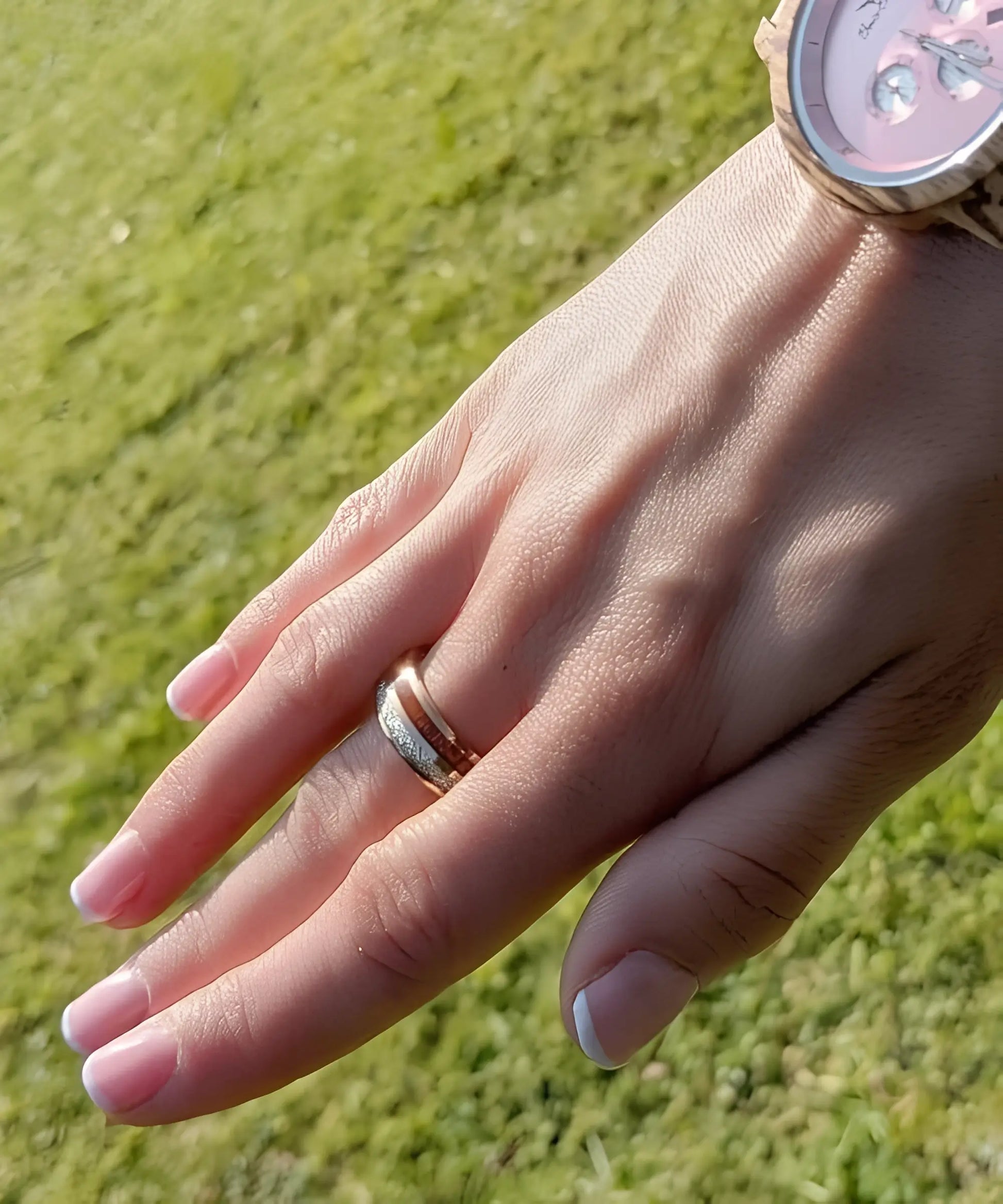 Bague femme Duo d’Eden en bois et acier rose délicat portée à la main avec manucure française en extérieur