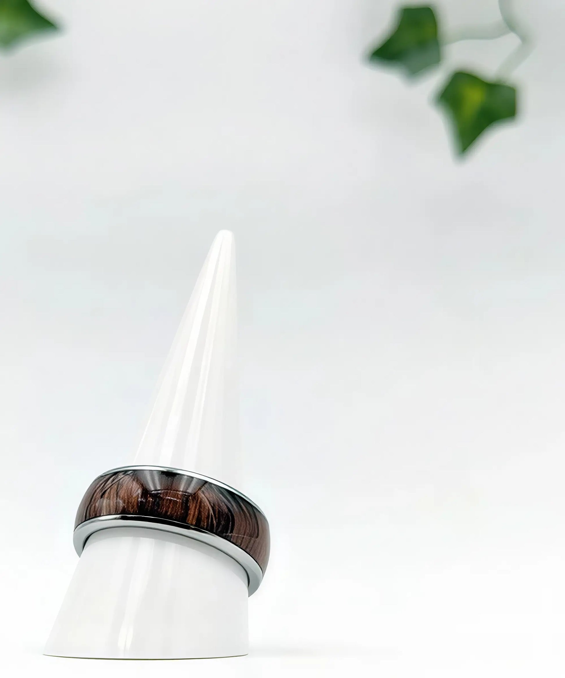 Bague homme Ouranos en bois et argent posée sur un présentoir blanc minimaliste