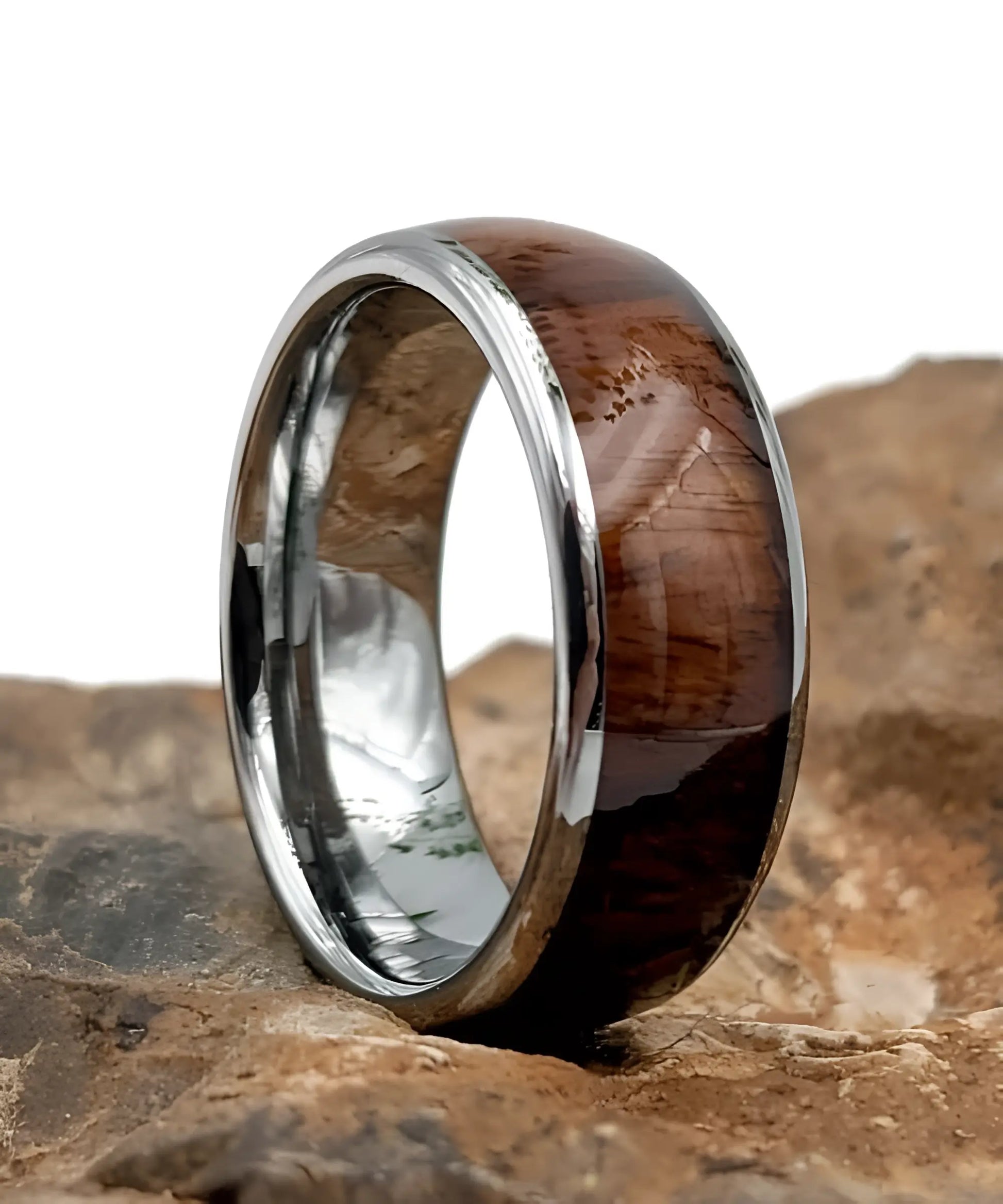 Bague homme Ouranos en bois de koa et tungstène argent posée sur un rocher - alliance élégante et naturelle