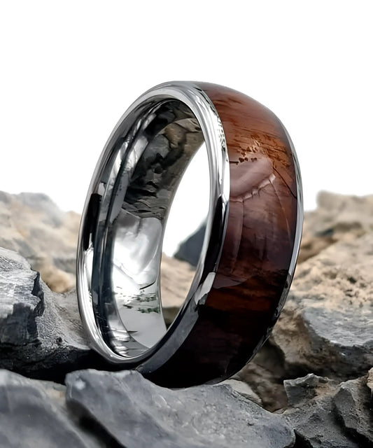 Bague homme Ouranos en bois de koa et tungstène argent posée sur des roches - alliance élégante et robuste