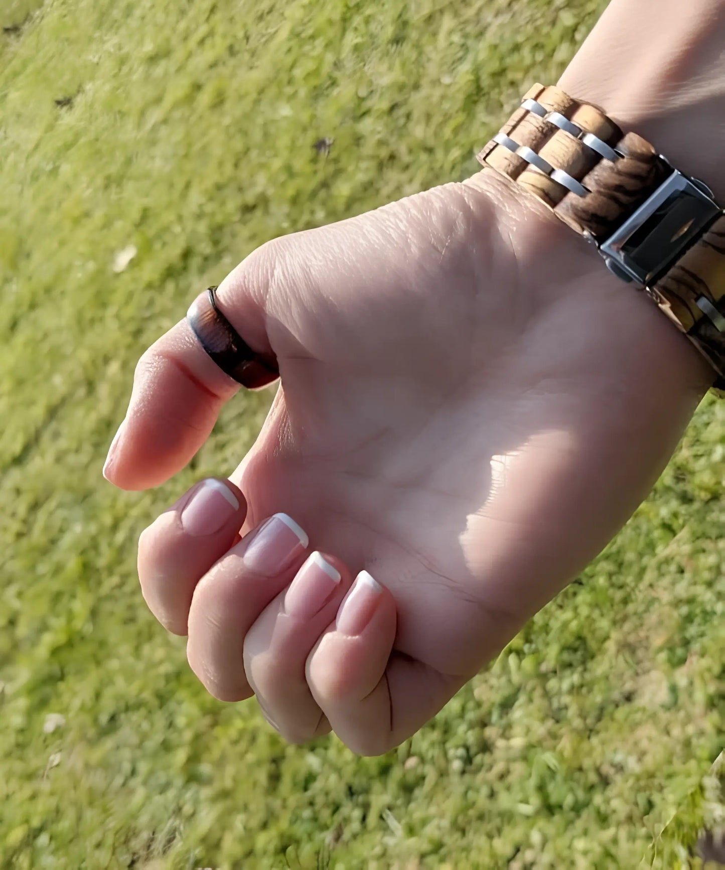 Bague Ouranos noire en tungstène et bois de koa portée au doigt, style élégant et naturel