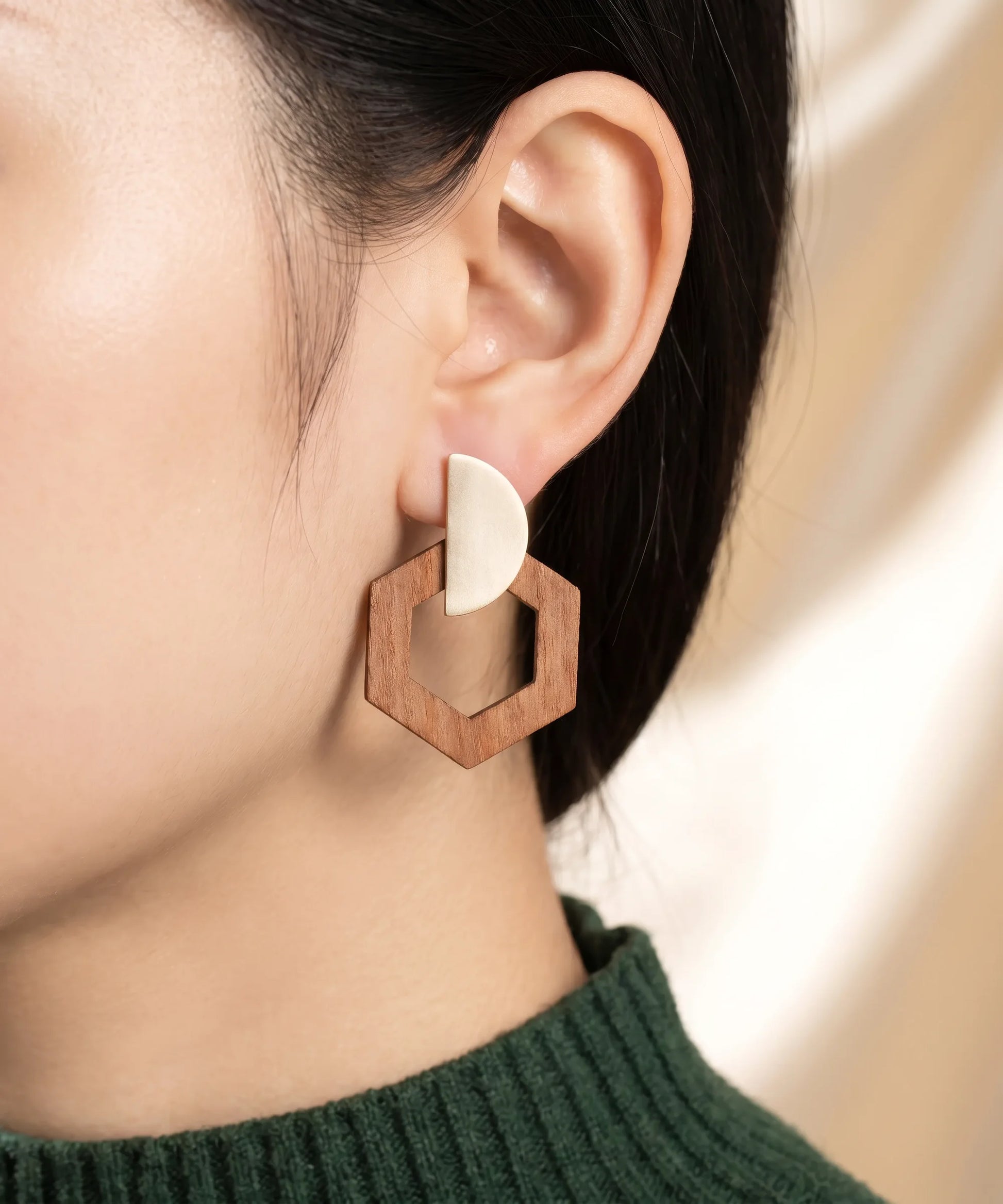Boucles d'oreilles en bois Corail Hexagone caramel portées, gros plan oreille, bijou élégant