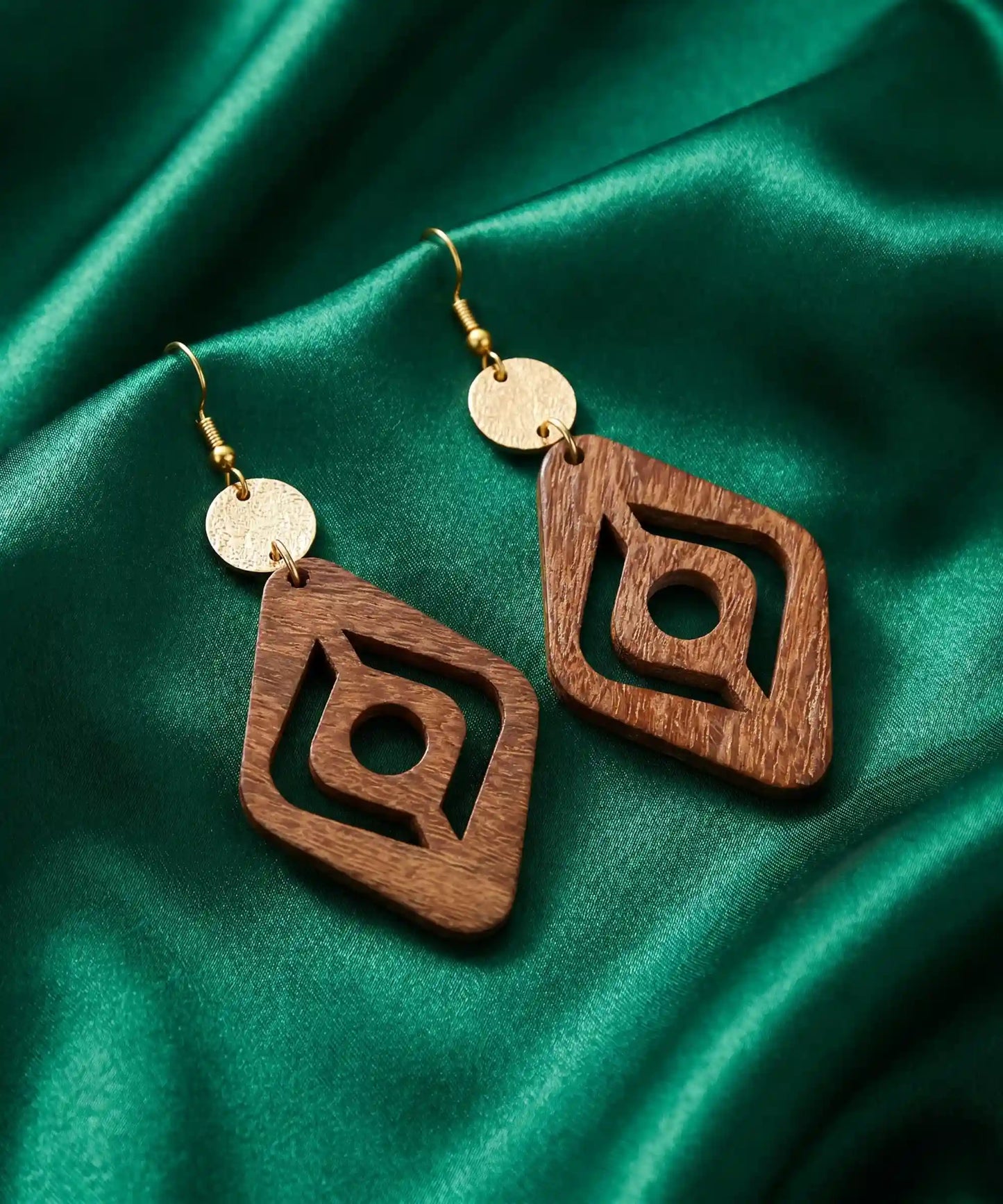 Boucles d'oreilles en bois Corail Losange évidé caramel sur satin vert émeraude, vue artistique élégante