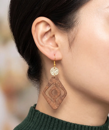 Boucles d'oreilles en bois Corail Losange évidé caramel portées, gros plan oreille, bijou élégant