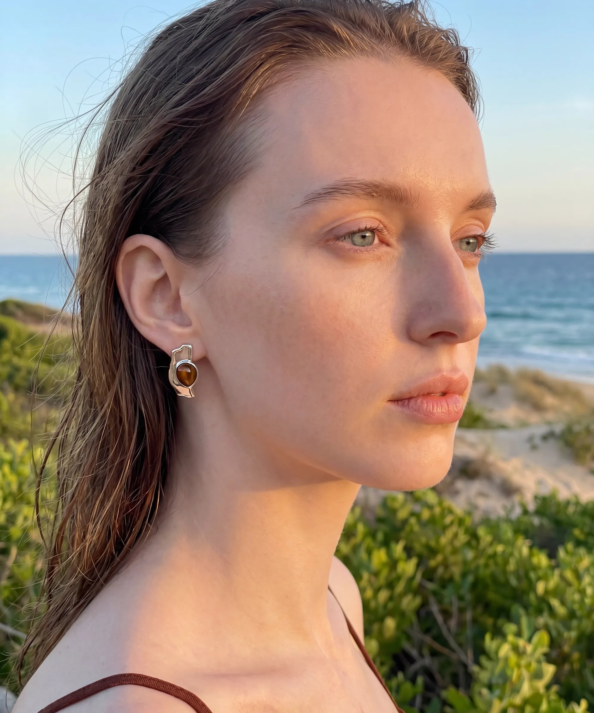Boucles d'oreilles en bois Ondine Argent portees par une femme au bord de mer, style naturel