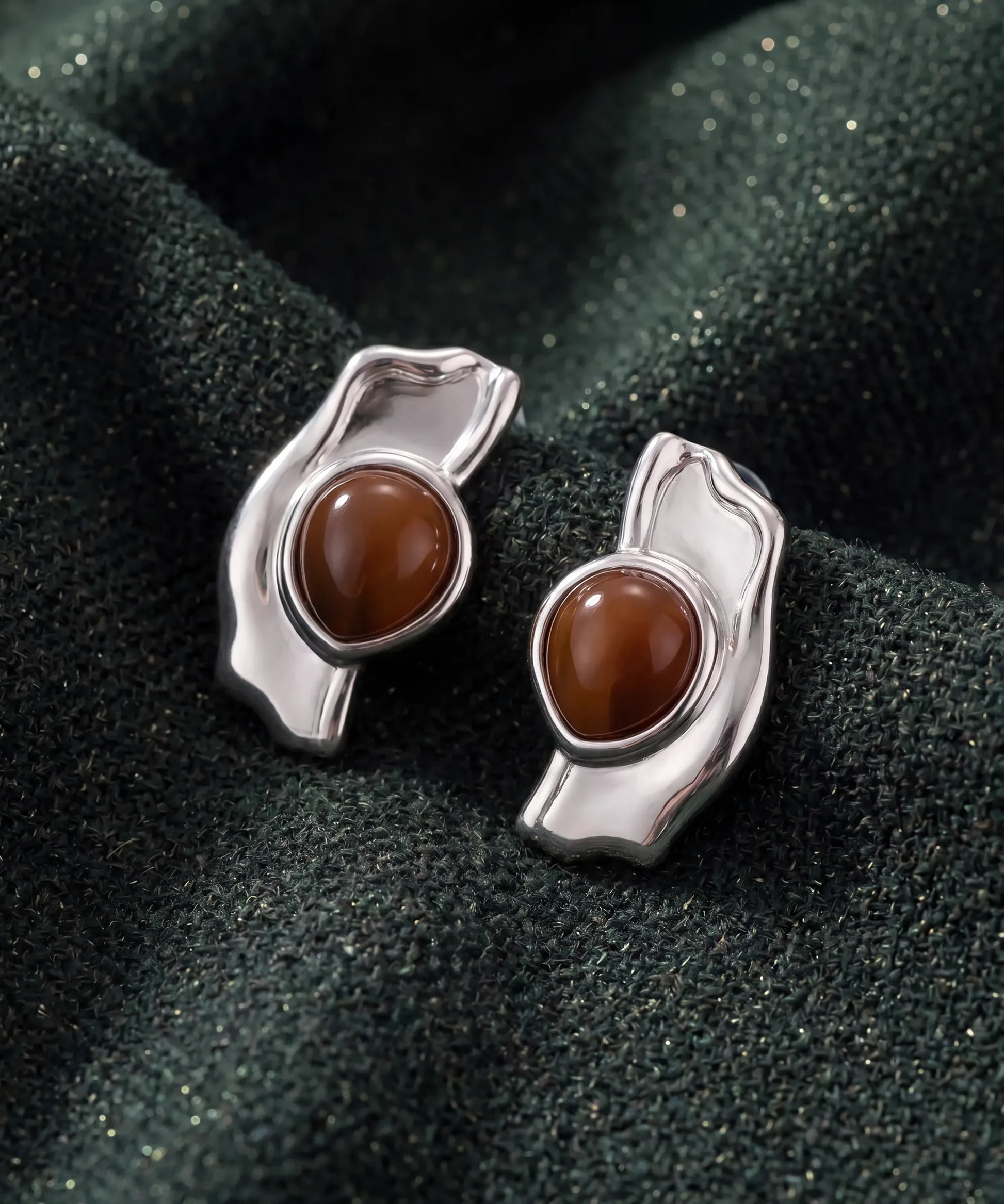 Boucles d'oreilles en bois Ondine Argent posees sur tissu vert, vue detaillee du bijou