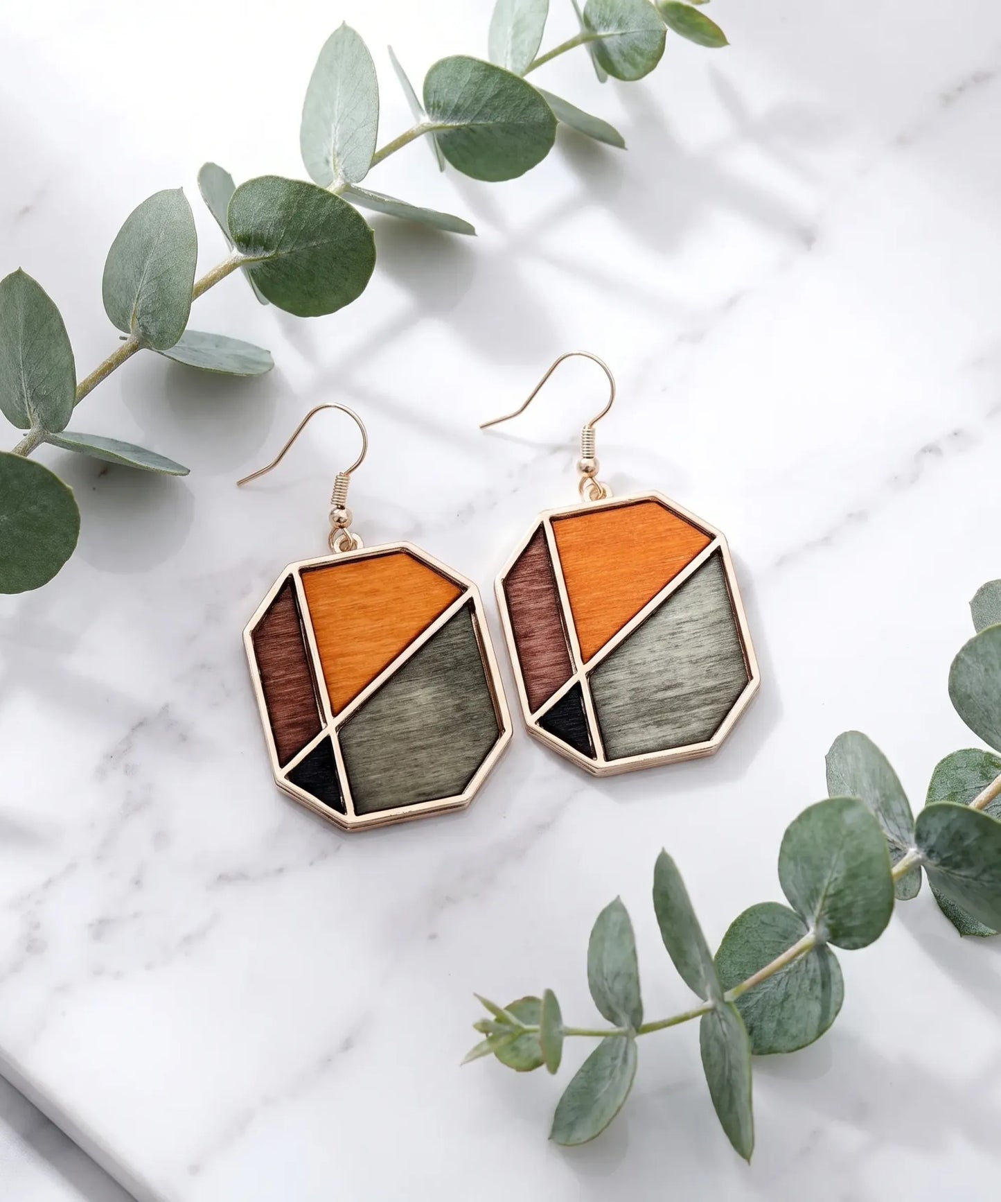 Boucles d'oreilles en bois Sylva Géométrique pentagone sur marbre et eucalyptus, vue artistique élégante