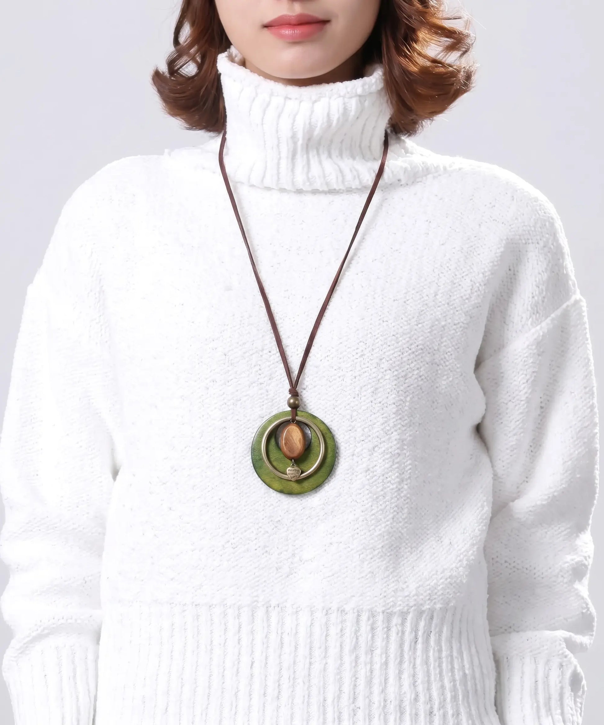 Pendentif bois porte par une femme avec col roule blanc, collier double anneau bohemes