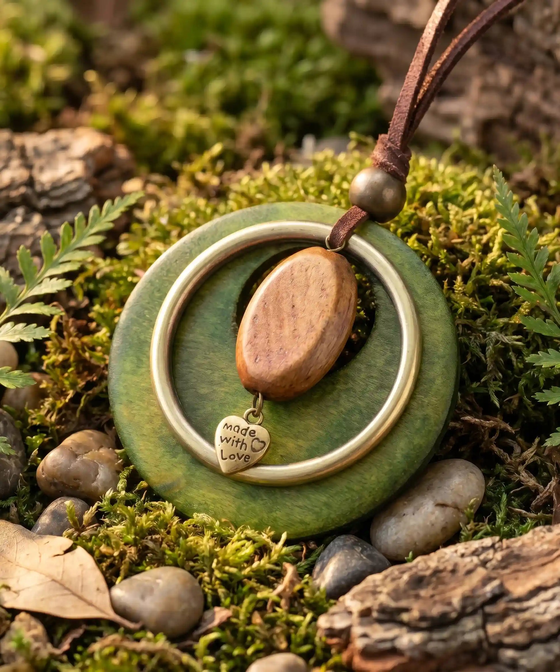 Pendentif bois vert sur lit de mousse et galets ronds, collier boheme inspire nature

